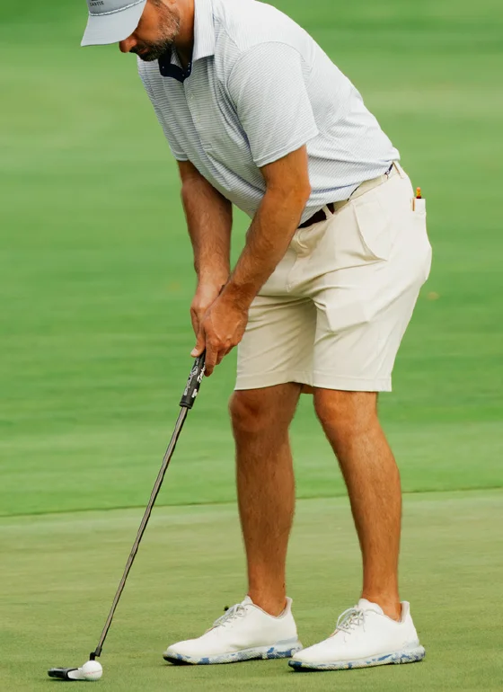 Golfer in Castle Golf Co. apparel putting